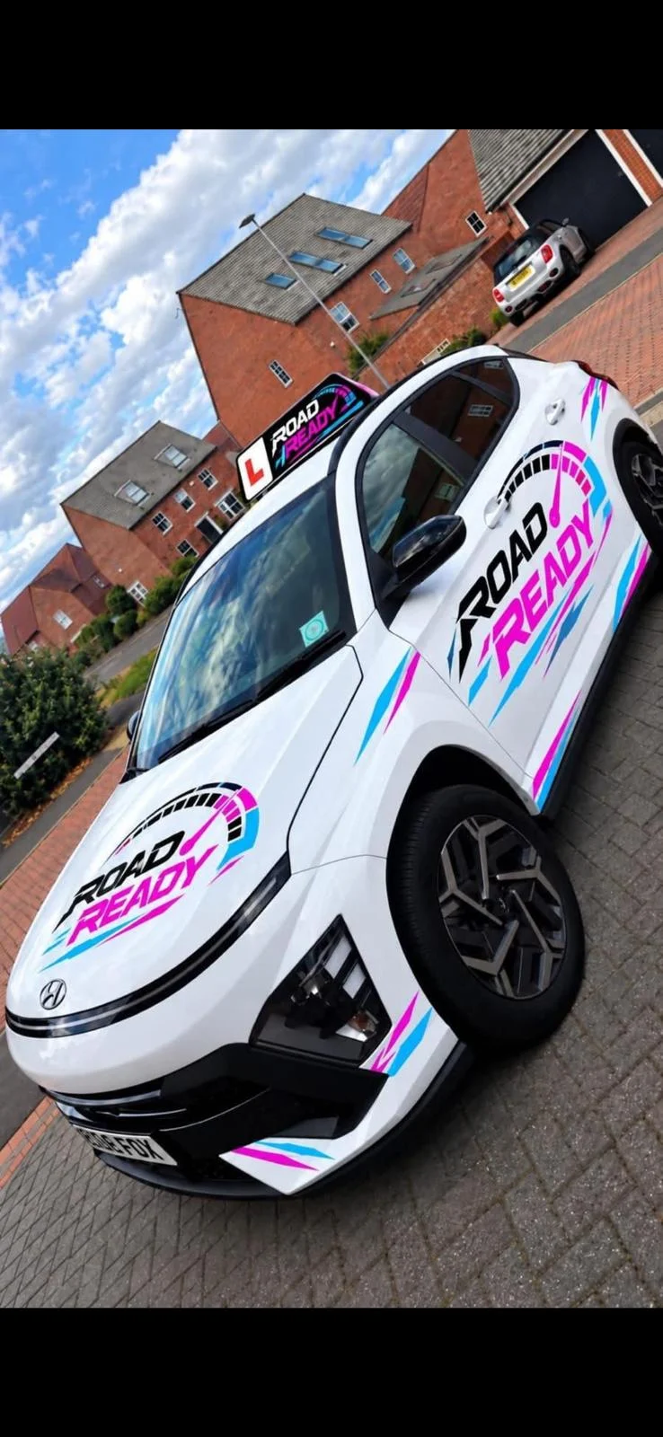White Hyundai Kona with Road Ready pink and cyan branding